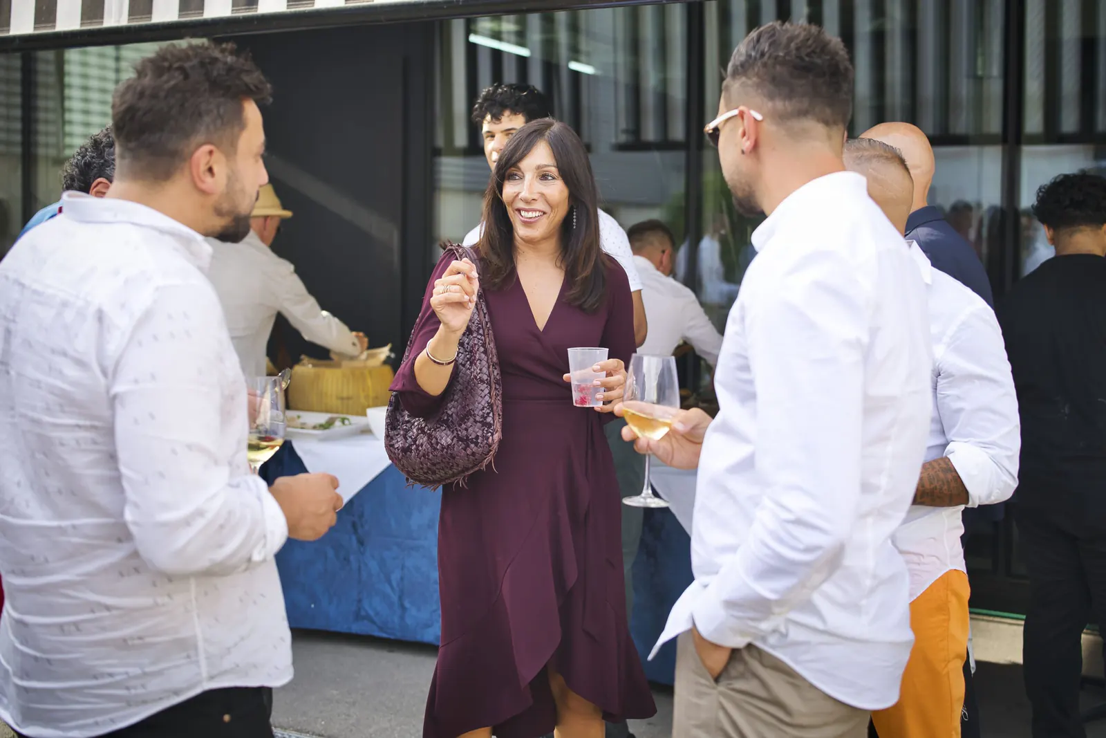 Gast im weinroten Kleid im Gespräch, Buffet im Hintergrund