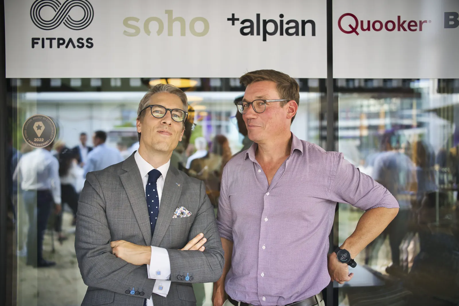 Zwei Gäste im Gespräch vor dem Sponsorenband des Networking Events