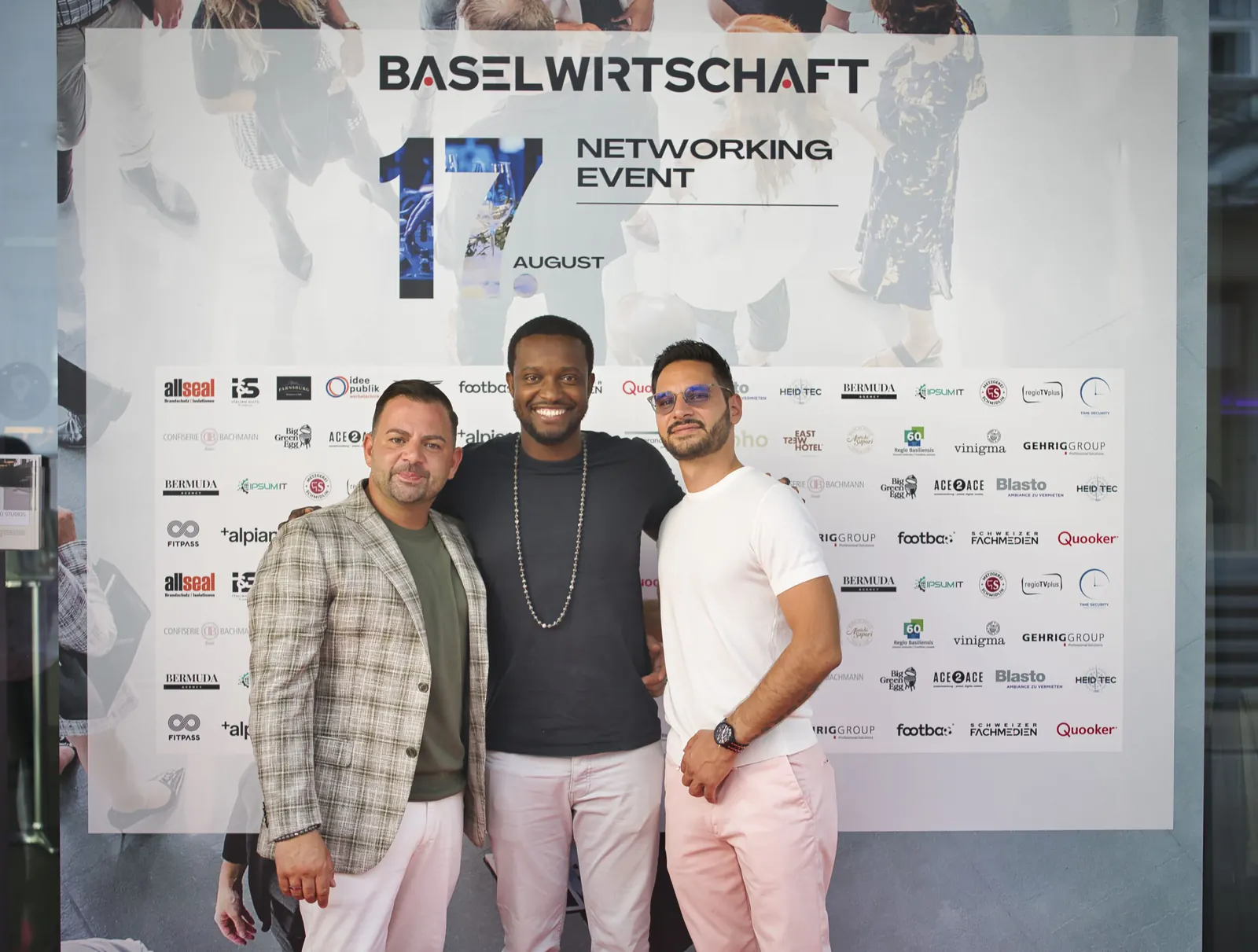 Gäste vor der Fotowand mit dem Schriftzug BASELWIRTSCHAFT Networking Event