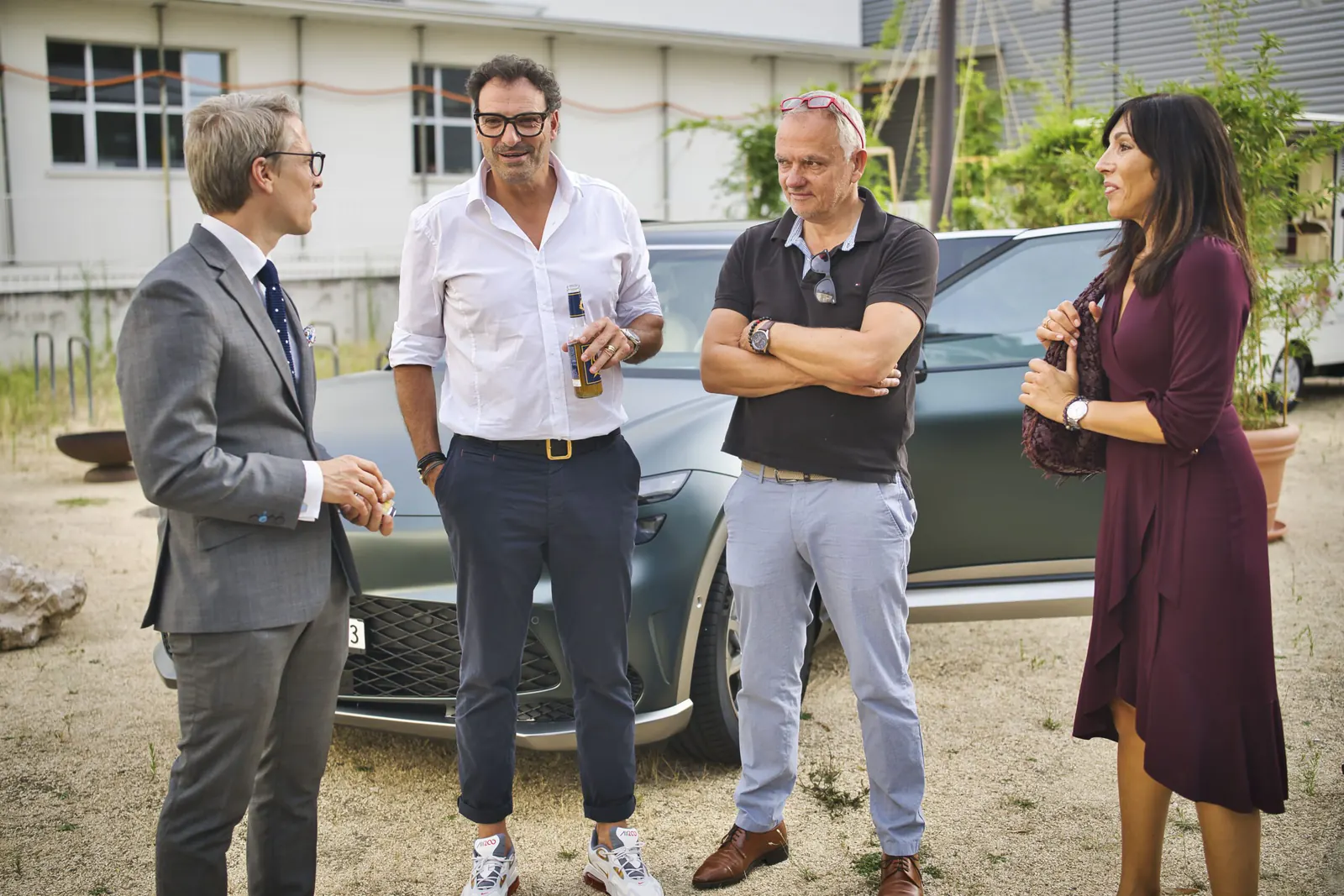 Vierergruppe im Gespräch, Anzug und Sommerhemd nebeneinander