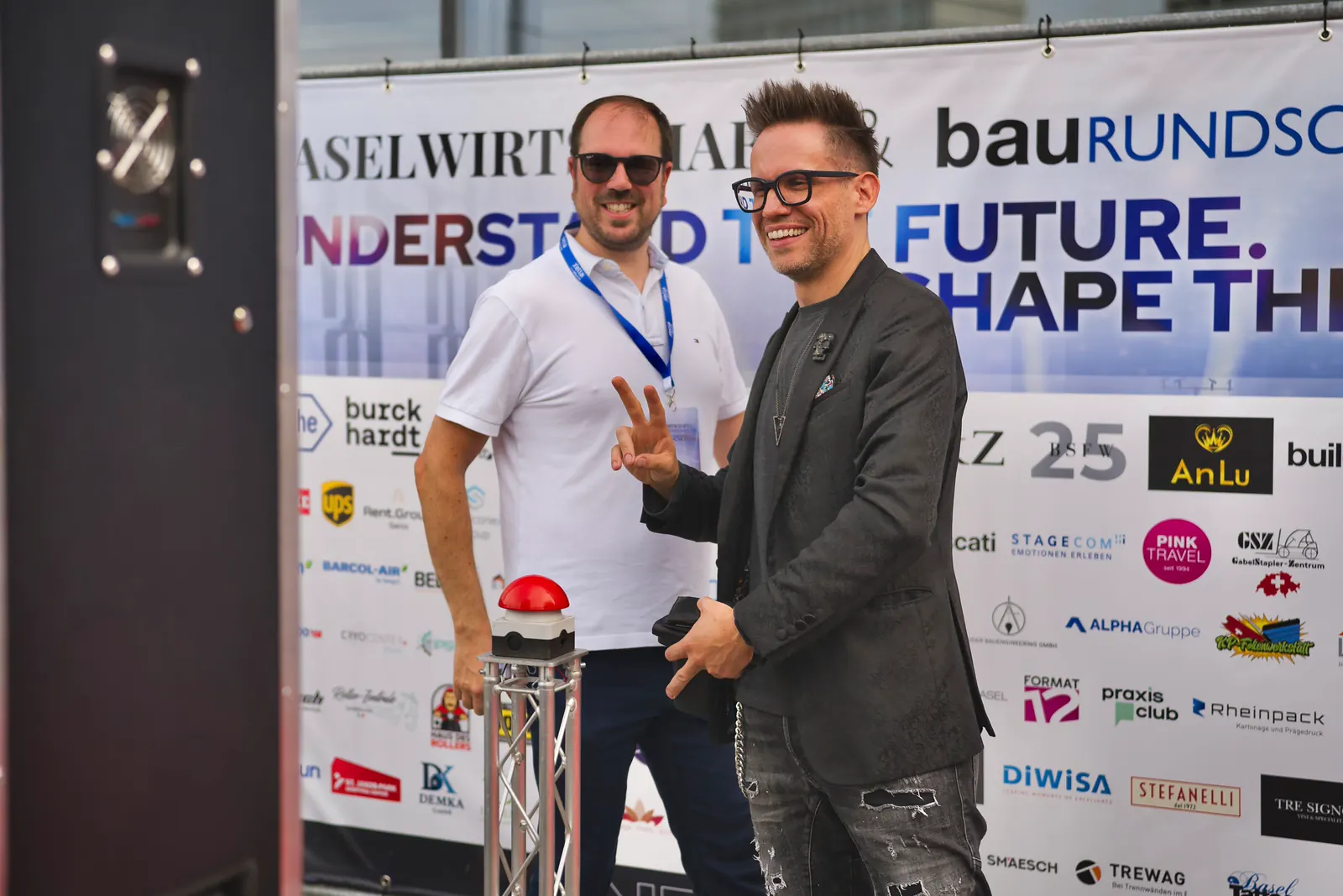 Zwei Gäste vor der Fotowand mit dem Schriftzug Understand the future, Shape the future